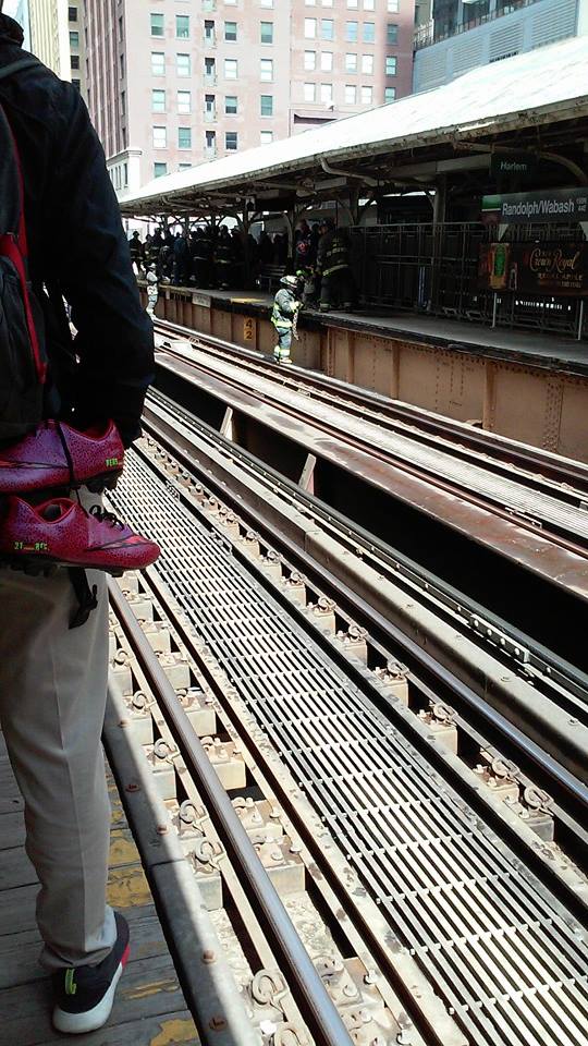 Fireman helping an old man that fell on the tracks